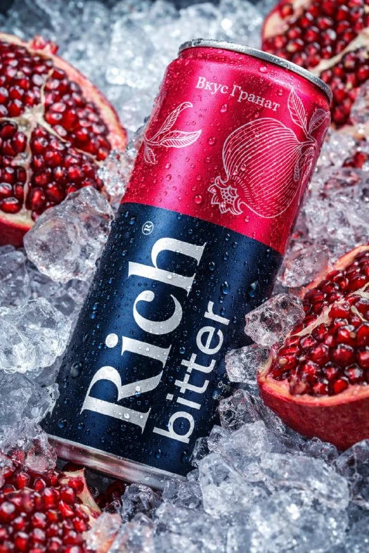 Lata de bebida con gotas de condensación entre frutas y hielo picado